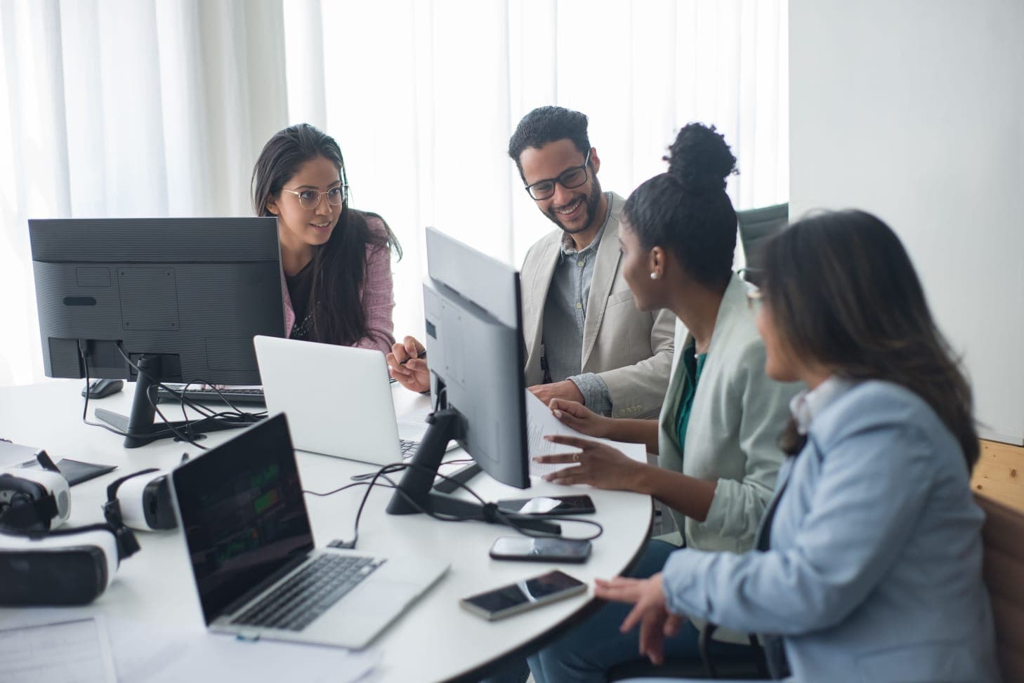 Equipe analisando sistemas em múltiplas telas no escritório